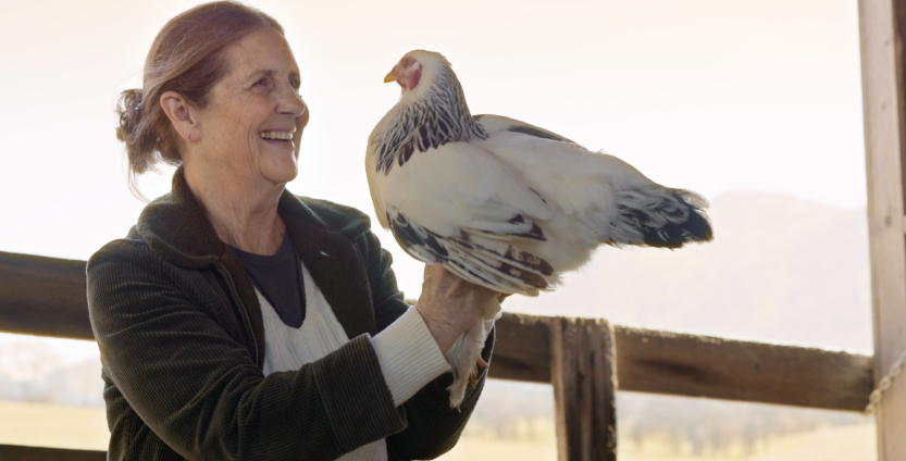 Woman holding chicken. Play video